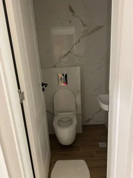 Smaller bathroom with a toilet and a washbasin. - image 2
