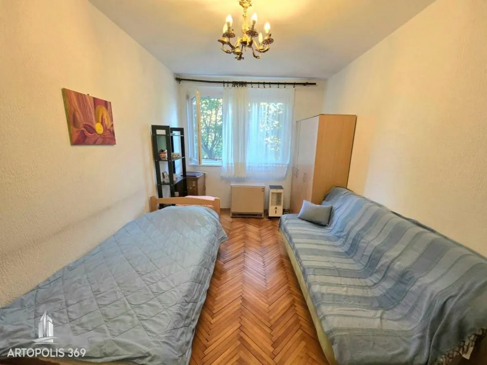 Nameštena spavaća soba sa dva kreveta i ormarom.