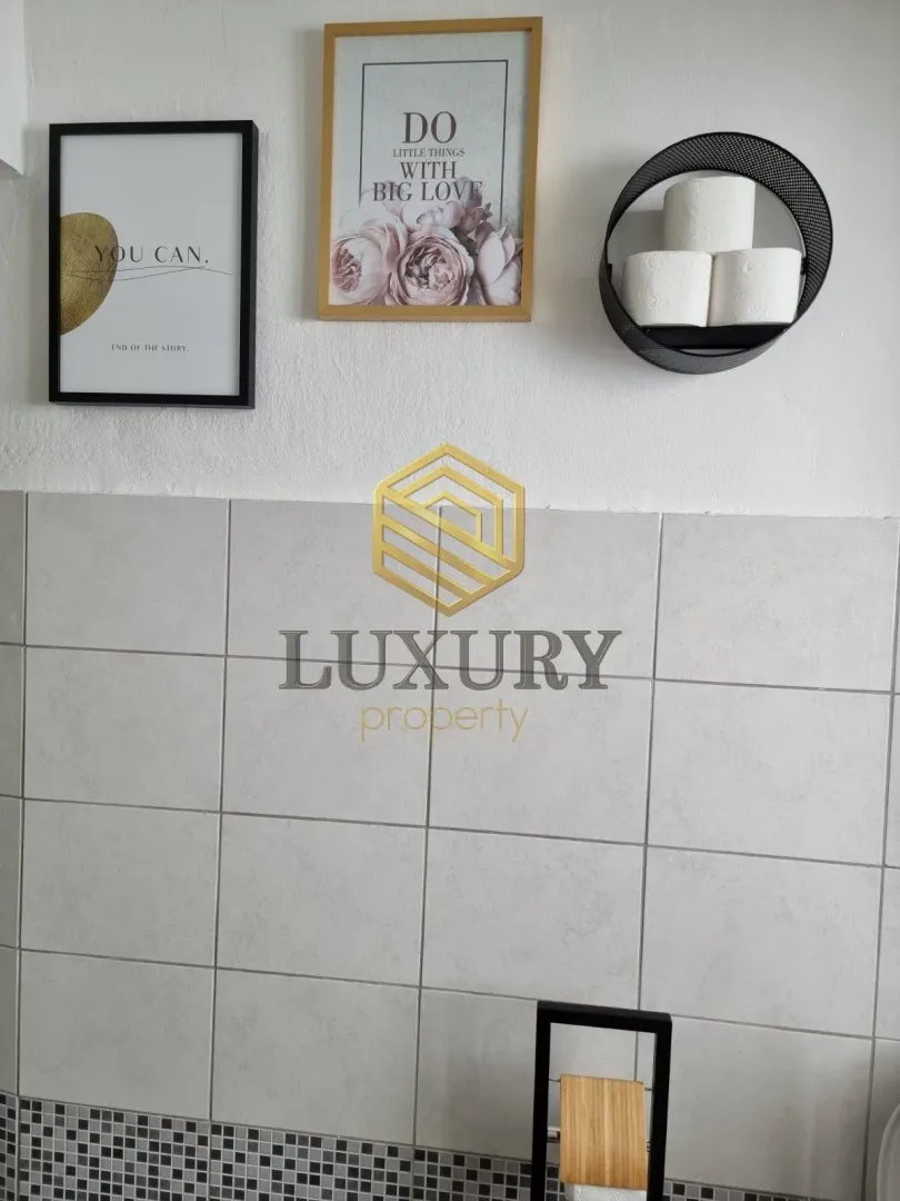 Detail of a decorated bathroom with wall decor.