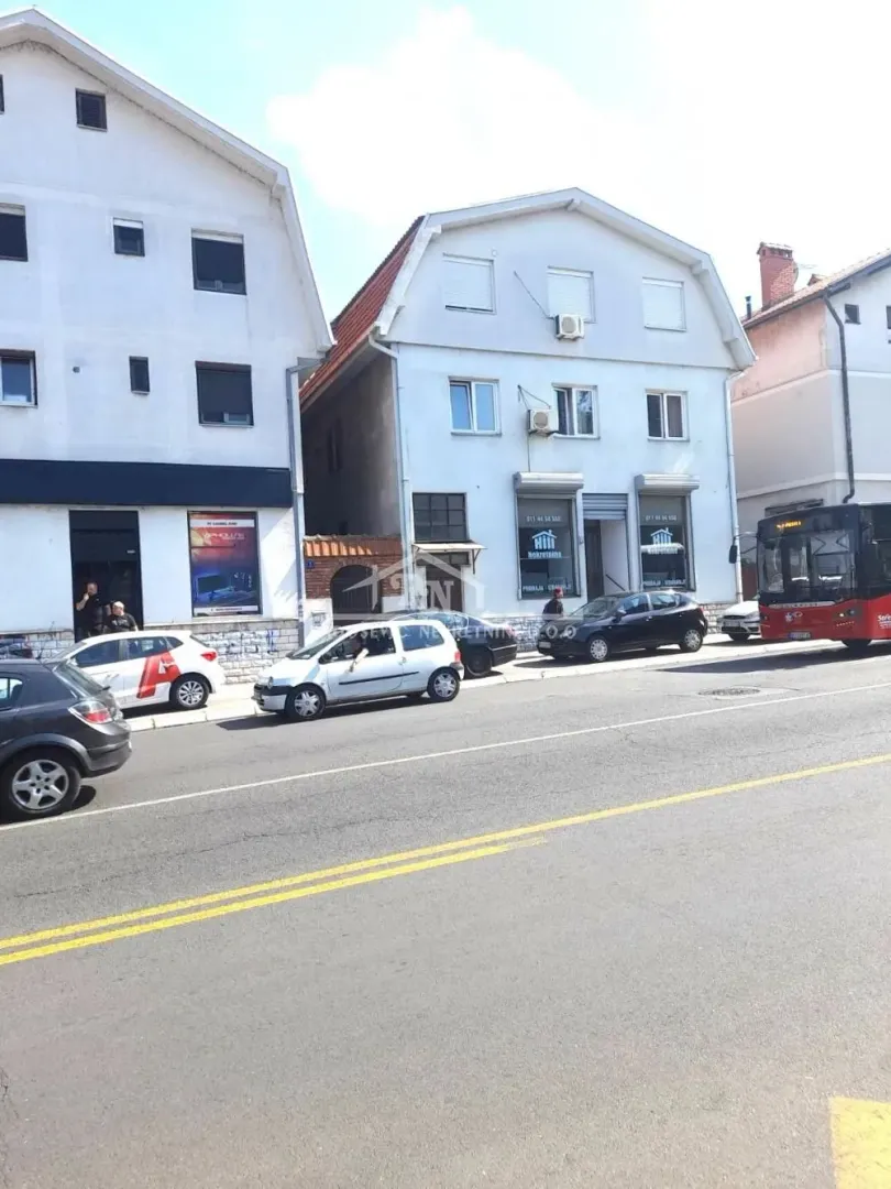 View of the building's exterior from the street with parked cars.