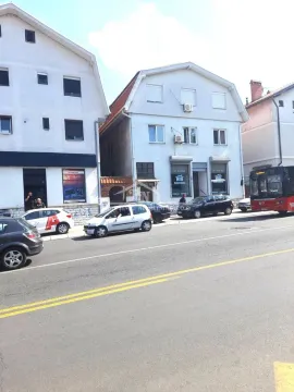 View of the building's exterior from the street with parked cars. - image 3