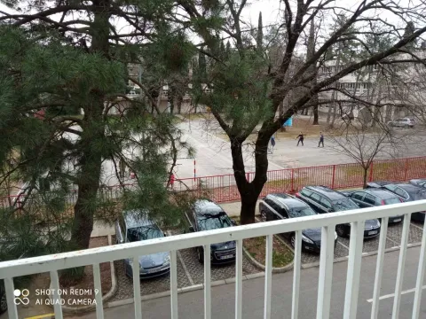 View from the terrace overlooking a parking lot and trees. - image 13