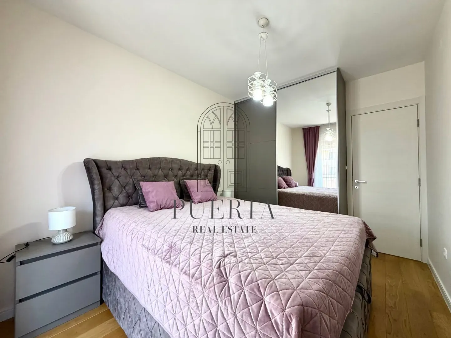 Bedroom with a double bed, mirrored wardrobe, and nightstand.