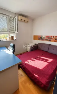 Manja spavaća soba sa krevetom, radnim stolom i klima uređajem. - image 7