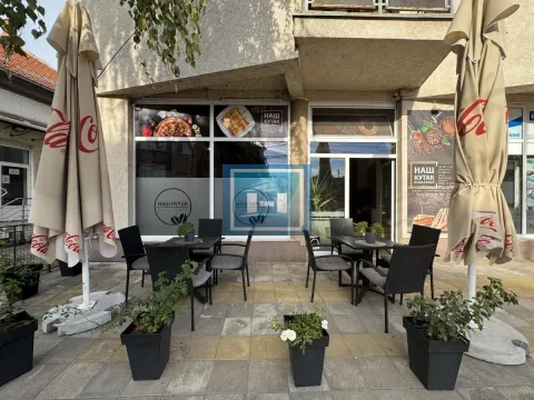 Eksterijer poslovnog prostora sa baštom i postavljenim stolovima i stolicama ispred ulaza. - image 16