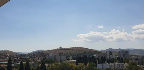 Panoramski pogled sa visine na grad i okolna brda. - image 17