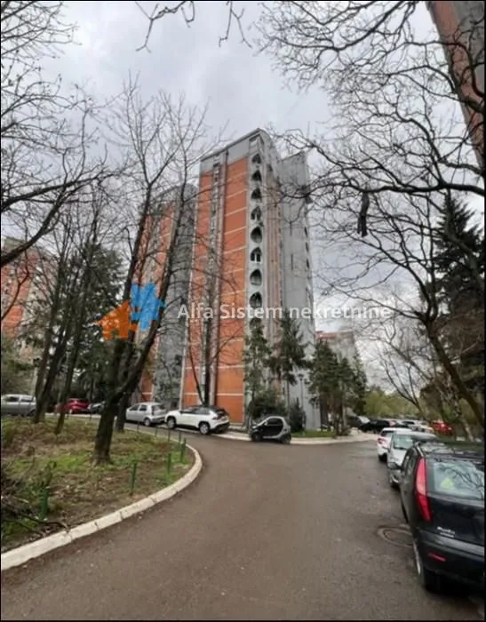 View of the exterior of the residential building and the surrounding yard with parking.