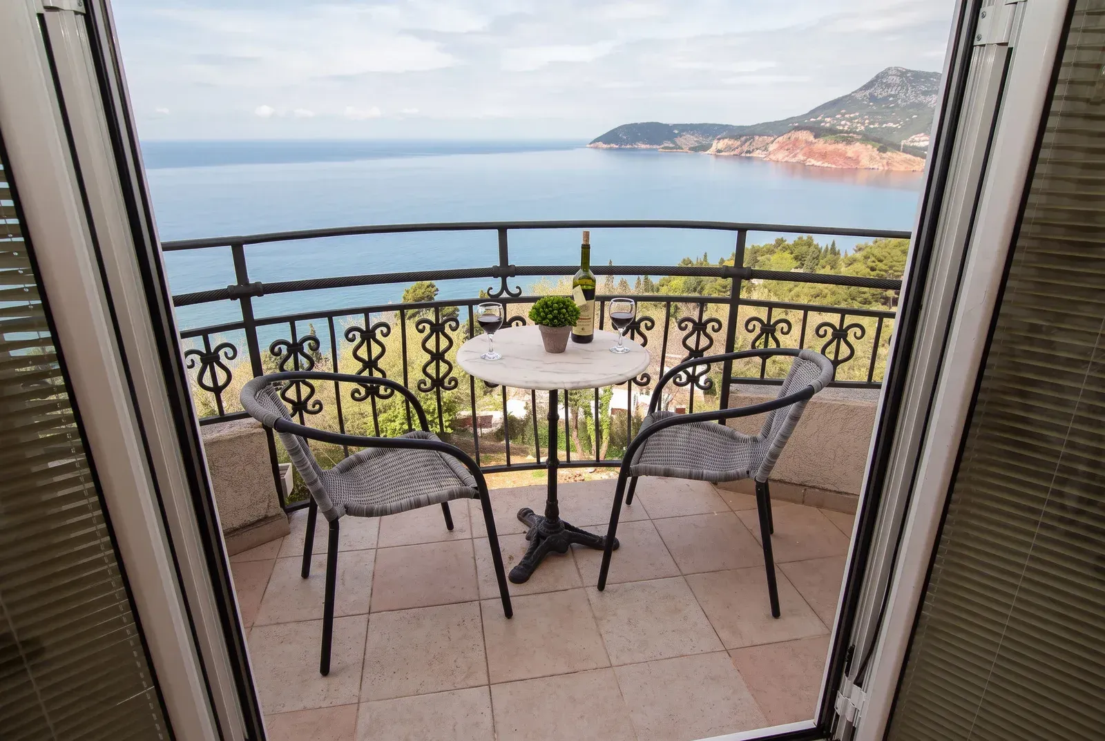 Namješten balkon sa stolom, stolicama i prelijepim pogledom na more.