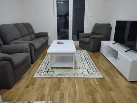 Furnished living room with a sofa set, coffee table, and TV. - image 3