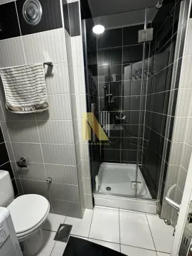 Kupatilo sa tuš kabinom, WC šoljom i belim pločicama. - image 9