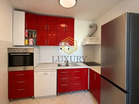Modern kitchen with red cabinets and built-in appliances. - image 5