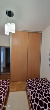Bedroom with a large built-in wardrobe and two beds. - image 18