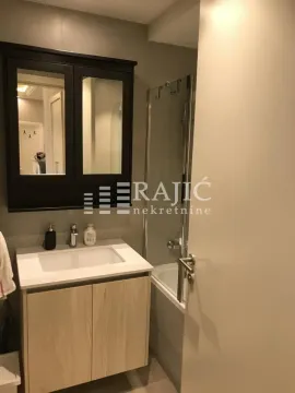 Small bathroom with a vanity, cabinet, and bathtub. - image 19