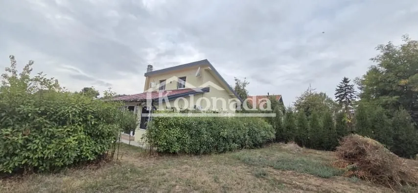 Pogled na spoljašnjost kuće sa dvorištem i zelenilom.