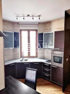 Smaller kitchen with dark cabinets and a dining table. - image 2