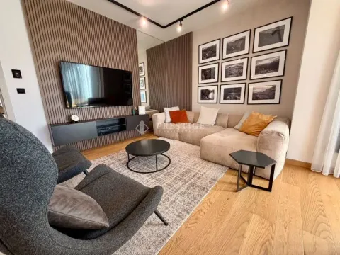 Modern and bright living room with a sofa, TV, and decorative wall panels. - image 3