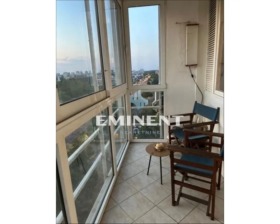 Enclosed balcony with seating furniture and a view of the surroundings.