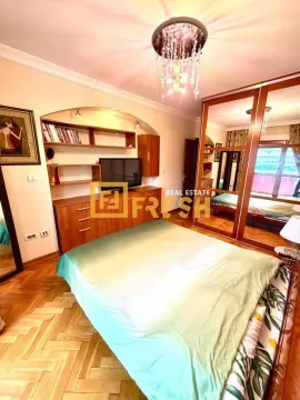 Furnished bedroom with a double bed, large wardrobe and TV unit. - image 5