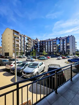 Pogled sa terase na stambenu zgradu i parking sa parkiranim automobilima. - image 3