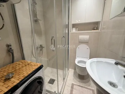 Modern bathroom equipped with a shower cabin, sink, and toilet. - image 11