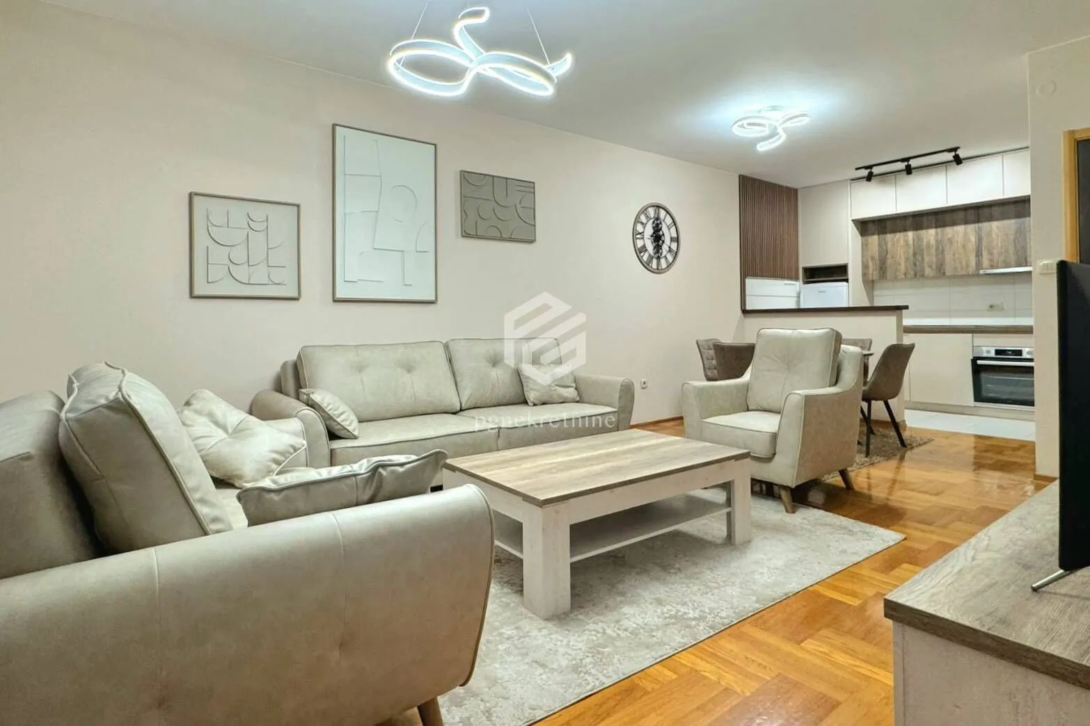 Living room with a sofa set, coffee table, and a view of the kitchen.
