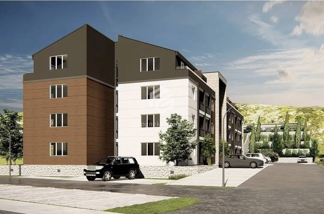 Exterior view of the residential building with parking and landscaped yard.