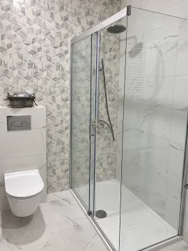 Modern bathroom with a shower cabin and a wall-mounted toilet. - image 8