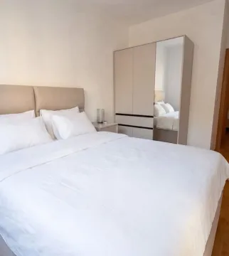 A furnished bedroom with a double bed and a wardrobe. - image 6