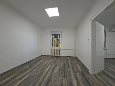 Empty room with white walls, dark laminate flooring, and a single window. - image 3
