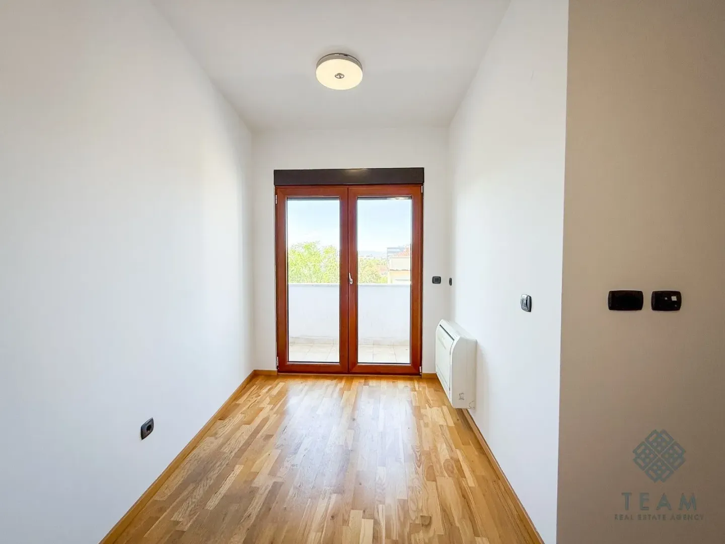 Empty room with parquet flooring and access to a terrace.
