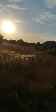 Pogled na plac i okolne kuće u prirodi tokom zalaska sunca. - image 2