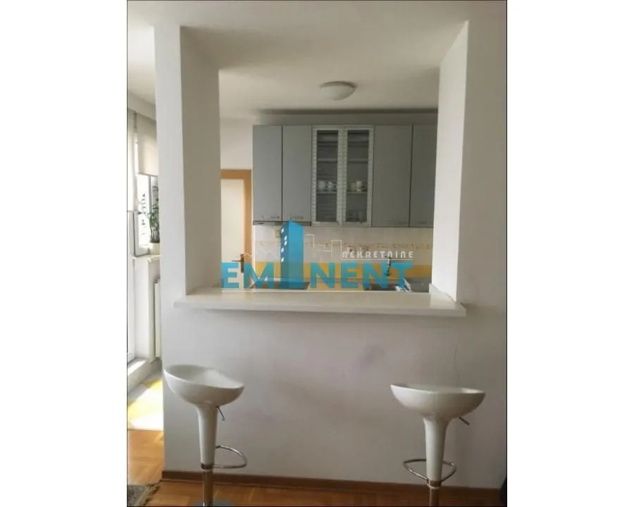 Small kitchen with a bar counter and bar stools.
