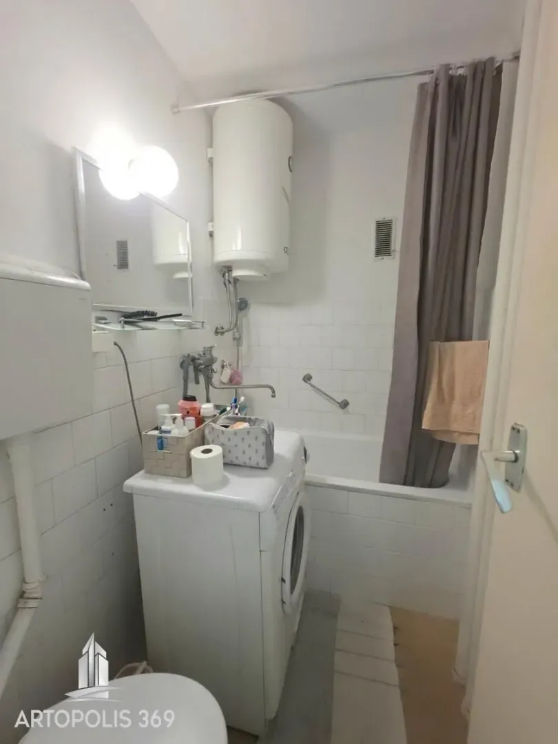 Manje kupatilo sa kadom, veš mašinom i bojlerom.