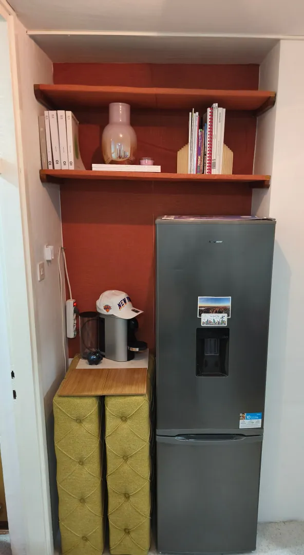 Manja kuhinjska niša sa frižiderom i policama za odlaganje.