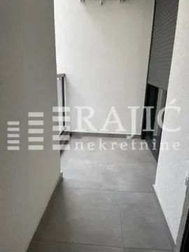 Small enclosed balcony with grey tiles and window shutters. - image 7