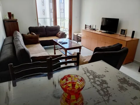 Living room with a sofa set, coffee table, television, and dining table in the foreground. - image 2