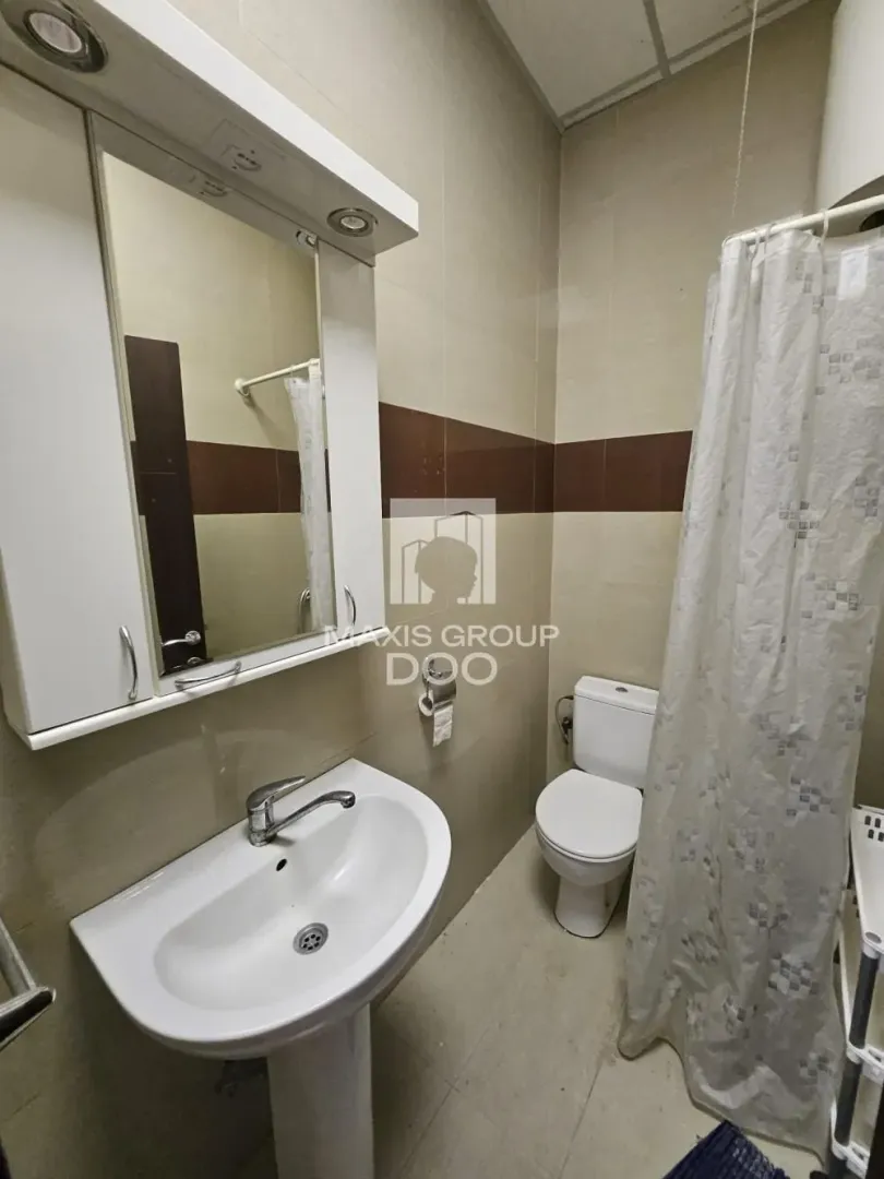 Bathroom with a sink, mirror, and toilet.