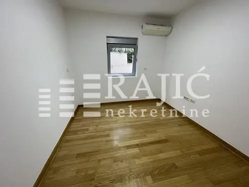 Empty room with wooden flooring and white walls.