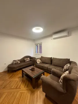 Living room with a sofa set, coffee table, and air conditioning unit. - image 2