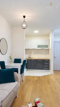 Manja kuhinja sa tamnim i bijelim elementima i trpezarijskim stolom u nastavku. - image 2