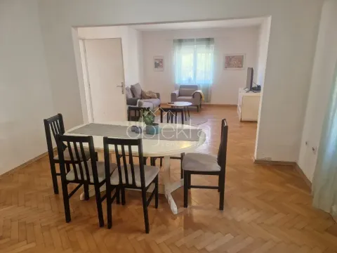 Dining area with a table and chairs, overlooking the living room in the background. - image 7