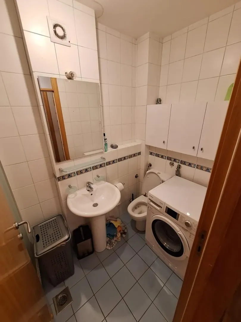 Kupatilo opremljeno umivaonikom, toaletom, tuš kabinom i veš mašinom.