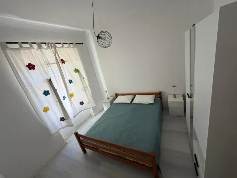 Spavaća soba sa bračnim krevetom, garderoberom i prozorom sa zavjesama. - image 6