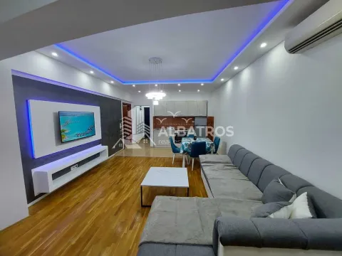 Spacious living room with a sectional sofa, TV unit, and dining area in the background. - image 2