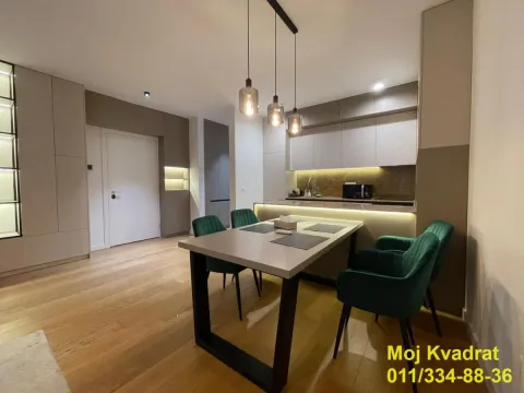 Modern kitchen with a dining area and built-in units. - image 9