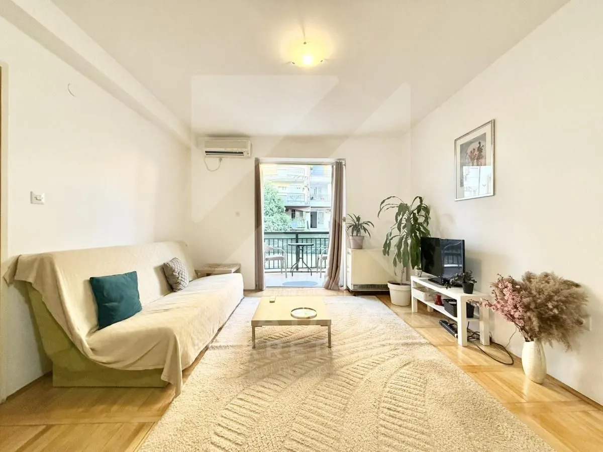 Living room with a sofa, TV, and access to the terrace.