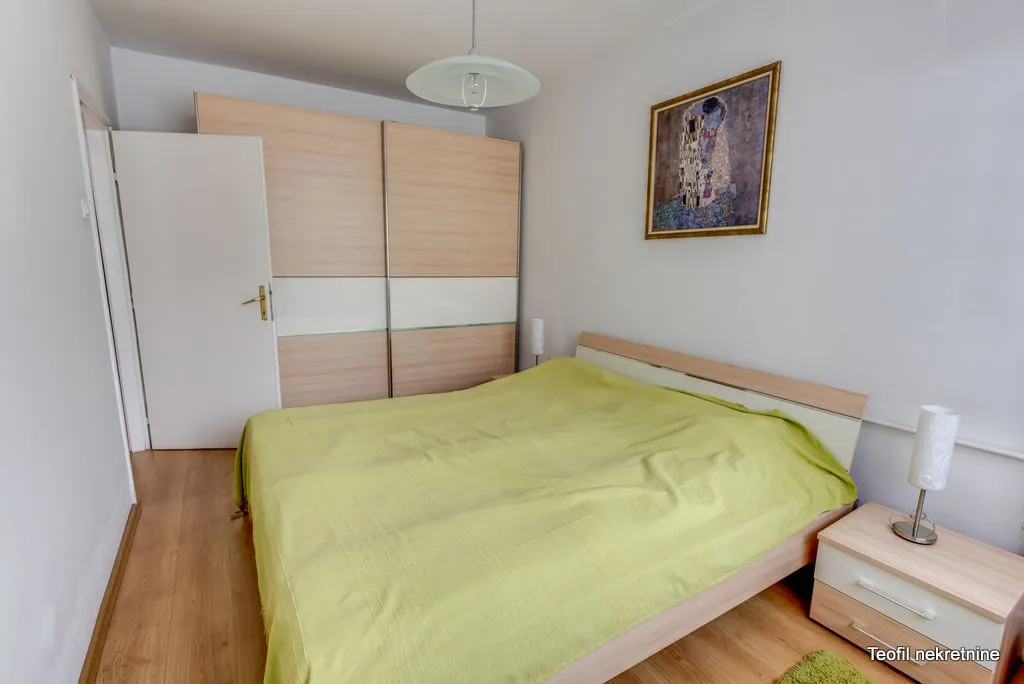Furnished bedroom with a double bed, large wardrobe, and a nightstand.