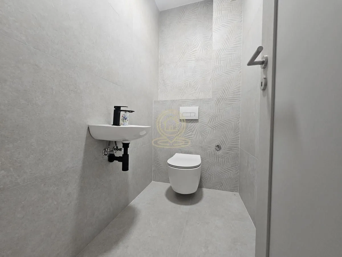Moderno opremljeno kupatilo sa šoljom, umivaonikom i WC šoljom.