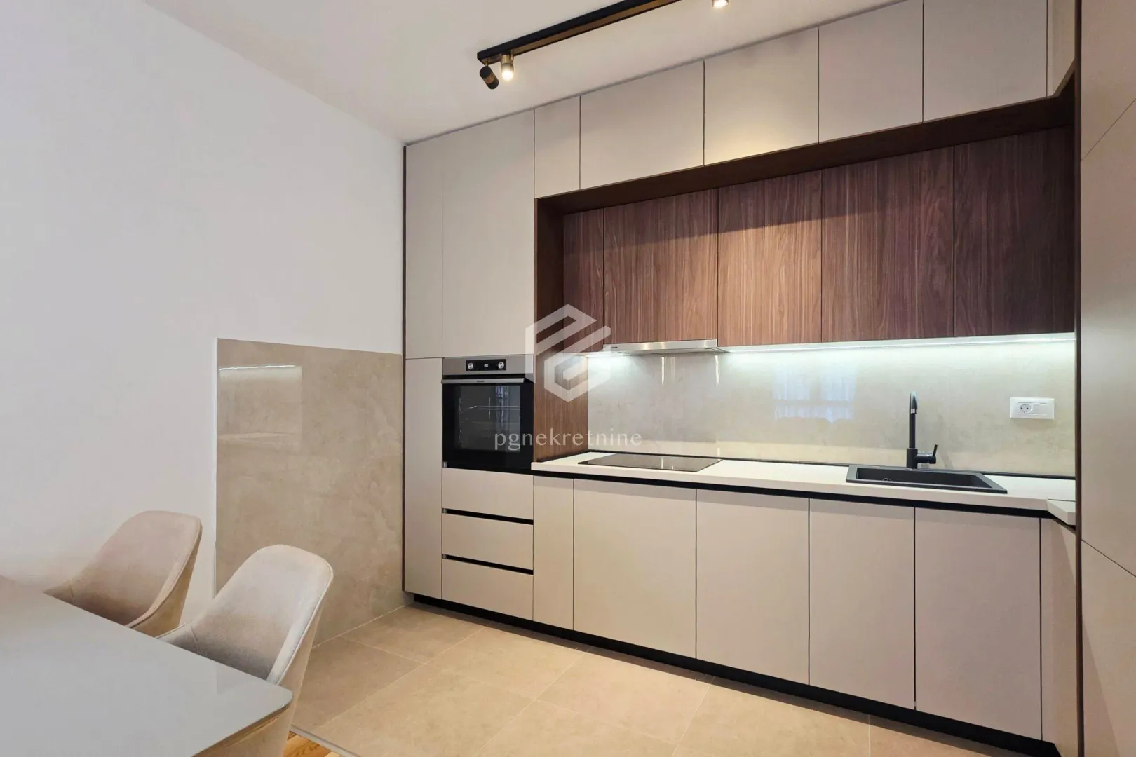 Modern kitchen with built-in appliances and a dining table.