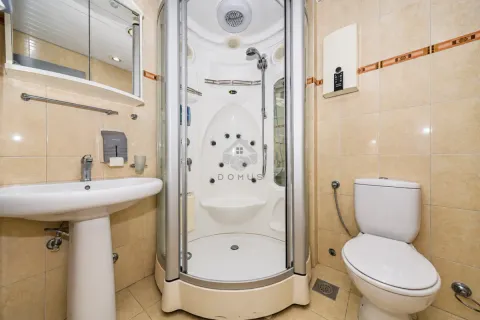 Bathroom equipped with a shower cabin, washbasin, and toilet. - image 7